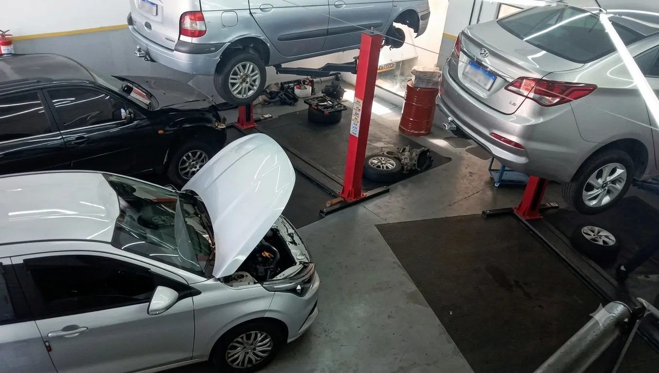 Interior da oficina A.RS Motors com vários veículos em manutenção sobre elevadores automotivos